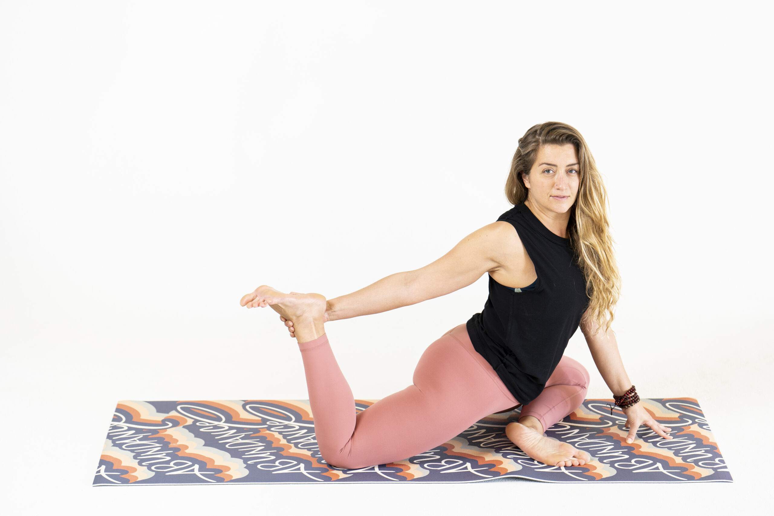 Female yoga teacher on a colorful mat.